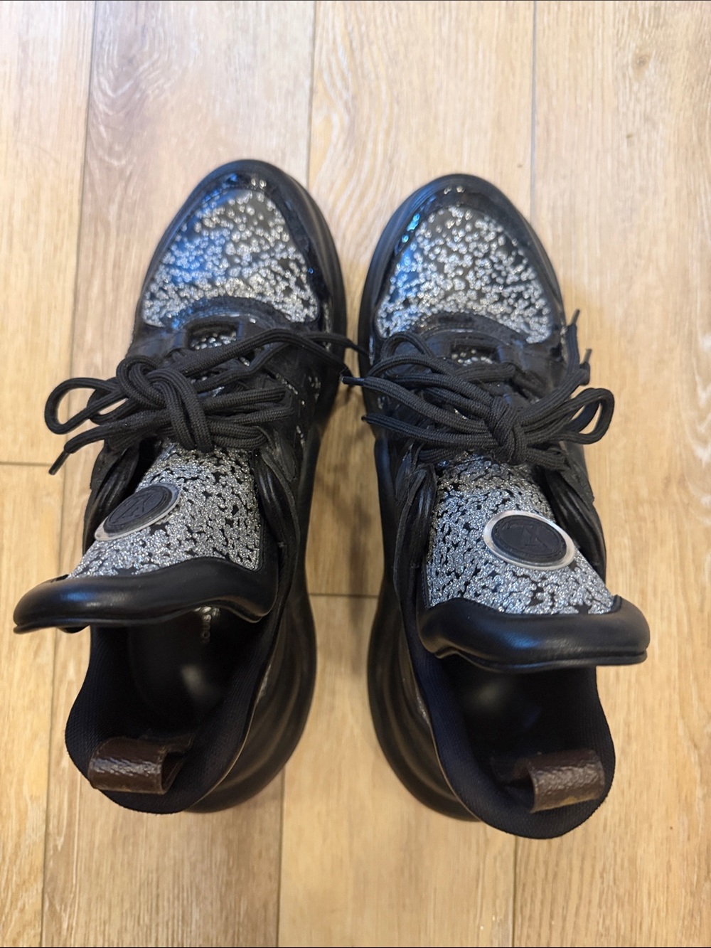 Louis Vuitton women’s sneakers black leather with silver sparkles throughout.